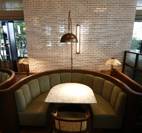 Restaurant booth seating with a sage green fabric and timber frame
