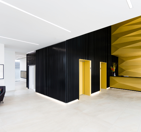 Concierge with bespoke reception desk, black metal clad walls, and lift lobby