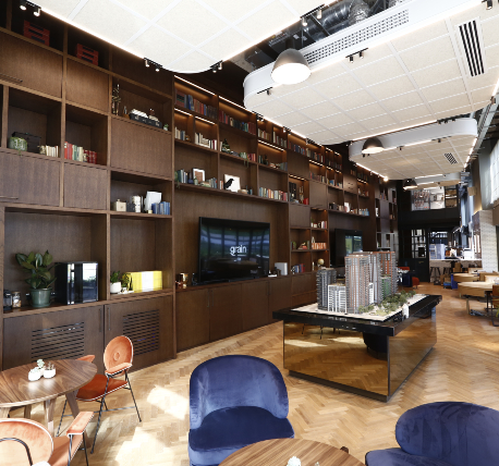 Restaurant lounge area with large bespoke storage unit in a dark walnut shade. With bespoke ceiling rafts