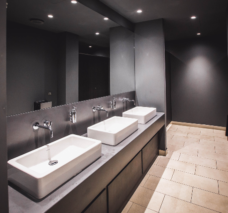 Gym changing room toilet area with sinks and mirrors