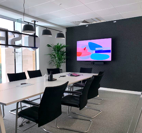 Office meeting room with table, black chairs and screen