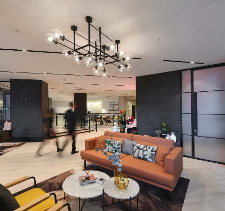 Office reception waiting area with orange sofa, modern light and light timber flooring