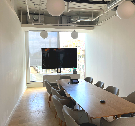 Meeting room with table, grey chairs and screen