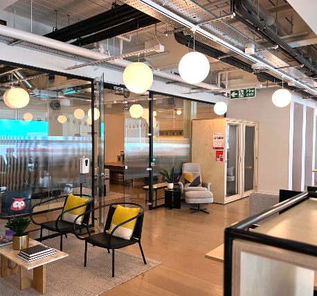 Open plan office with glazed partition wall and acoustic office pods